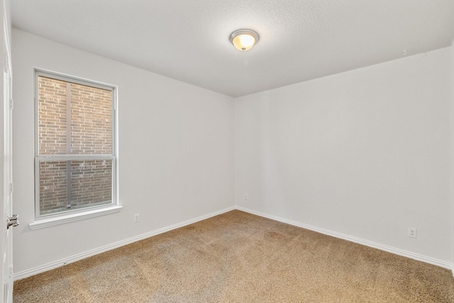 carpeted empty room with a textured ceiling