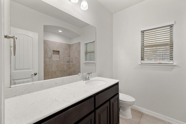 bathroom featuring tile patterned flooring, toilet, vanity, and walk in shower