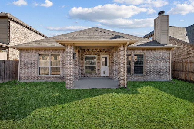 rear view of property featuring a patio area and a lawn