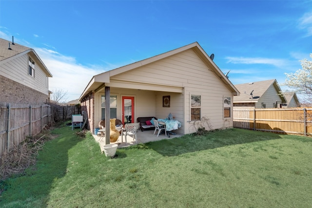 rear view of house with a yard and a patio area