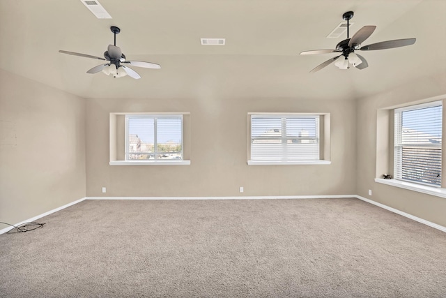 empty room featuring ceiling fan, a healthy amount of sunlight, carpet flooring, and vaulted ceiling