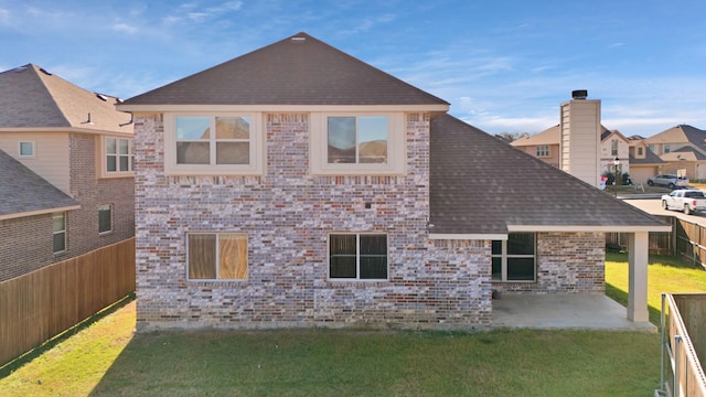 back of house with a lawn and a patio area