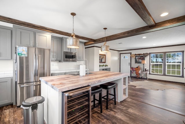 kitchen featuring stainless steel appliances, butcher block counters, gray cabinets, a sink, and beverage cooler