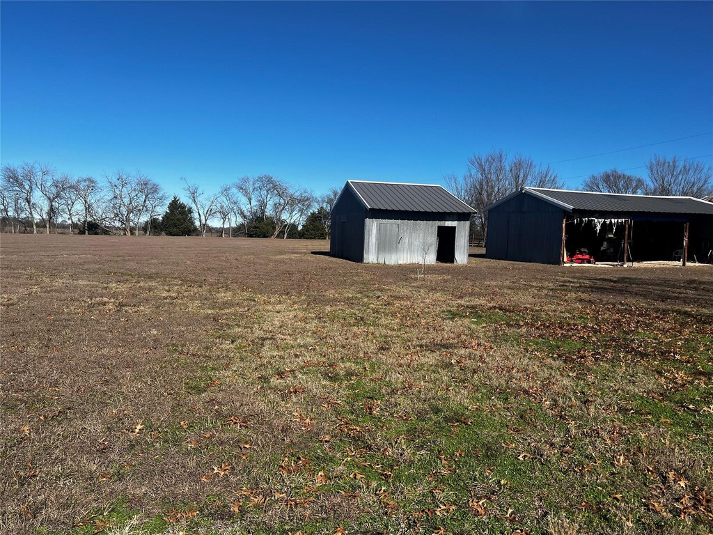 view of yard featuring a rural view and an outdoor structure