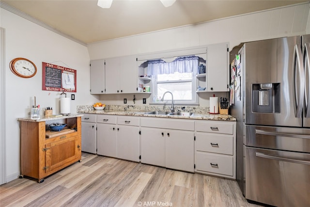 kitchen featuring white cabinetry, sink, light stone counters, stainless steel refrigerator with ice dispenser, and light wood-type flooring