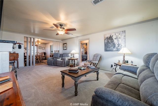 living room featuring ceiling fan, ornamental molding, and light carpet