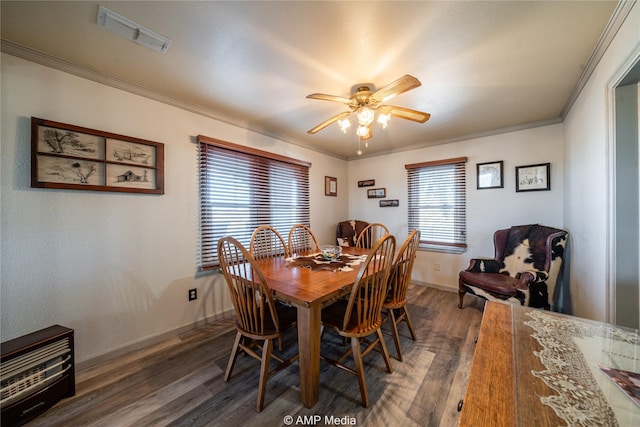 dining space with crown molding, ceiling fan, and dark wood-type flooring