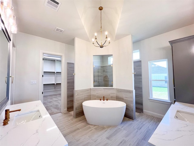 bathroom with vanity, a notable chandelier, and plus walk in shower