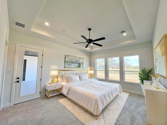 carpeted bedroom featuring a raised ceiling, ceiling fan, and access to outside