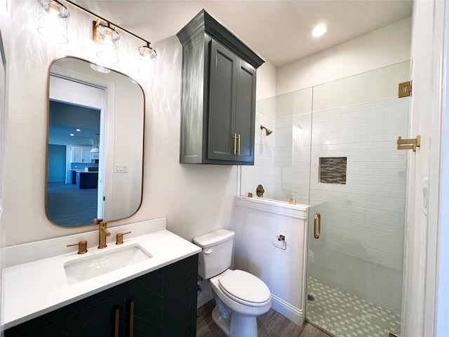 bathroom with wood-type flooring, vanity, a shower with shower door, and toilet