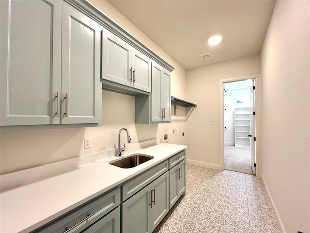 kitchen with gray cabinets, light tile patterned floors, and sink