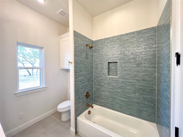 bathroom with toilet, tile patterned floors, and tiled shower / bath