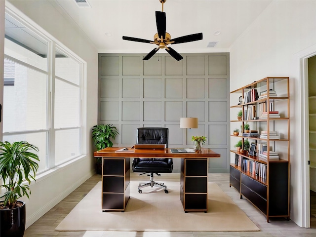 office with light hardwood / wood-style floors, ceiling fan, and crown molding