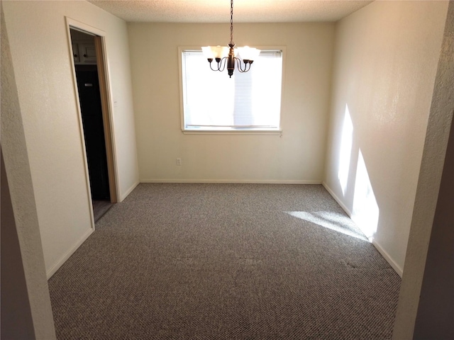 carpeted spare room with an inviting chandelier