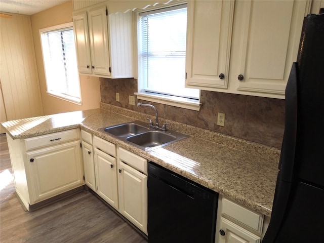 kitchen featuring kitchen peninsula, dark wood-type flooring, sink, black appliances, and white cabinets