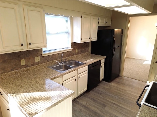 kitchen featuring sink, black dishwasher, dark hardwood / wood-style floors, stove, and white cabinets