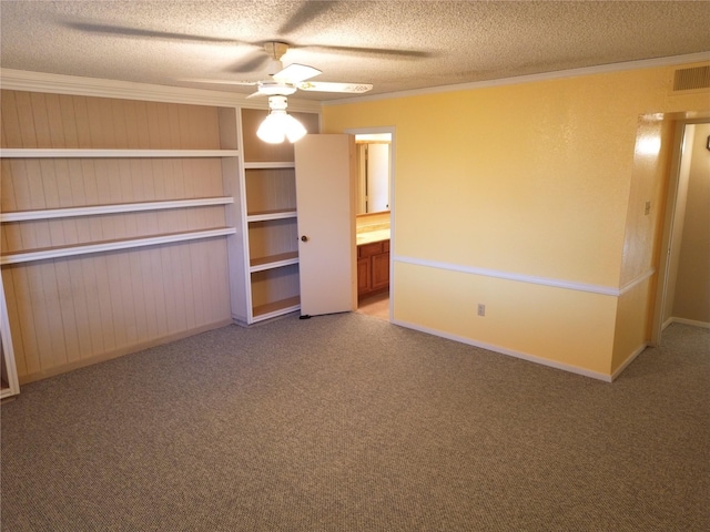 unfurnished bedroom featuring carpet, crown molding, ceiling fan, a textured ceiling, and connected bathroom