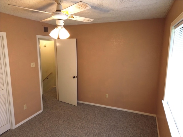 unfurnished bedroom with carpet, a textured ceiling, and ceiling fan