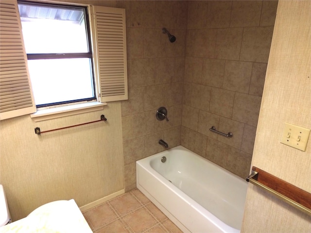 bathroom with tile patterned floors, tiled shower / bath combo, and toilet