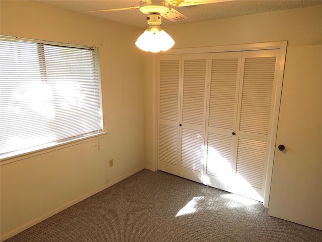 unfurnished bedroom with ceiling fan, carpet floors, and a closet