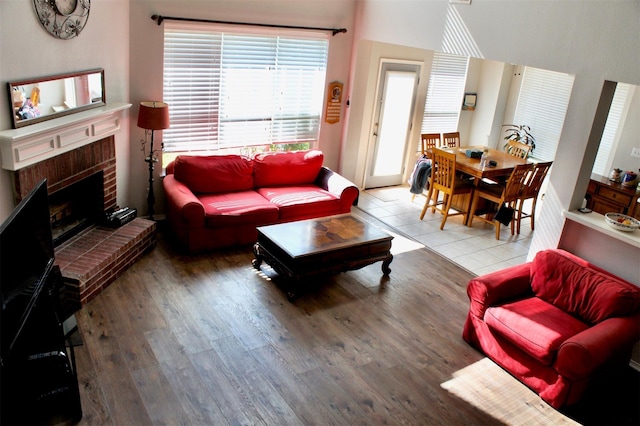 living room with hardwood / wood-style flooring and a brick fireplace