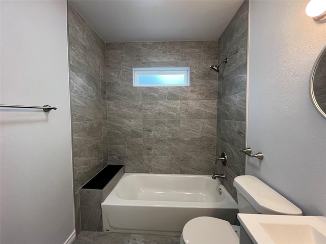 full bathroom featuring vanity, tiled shower / bath, and toilet