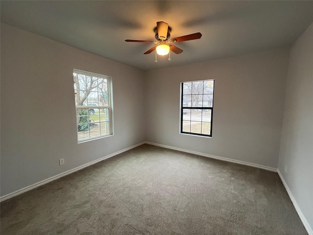 carpeted empty room with ceiling fan and a healthy amount of sunlight