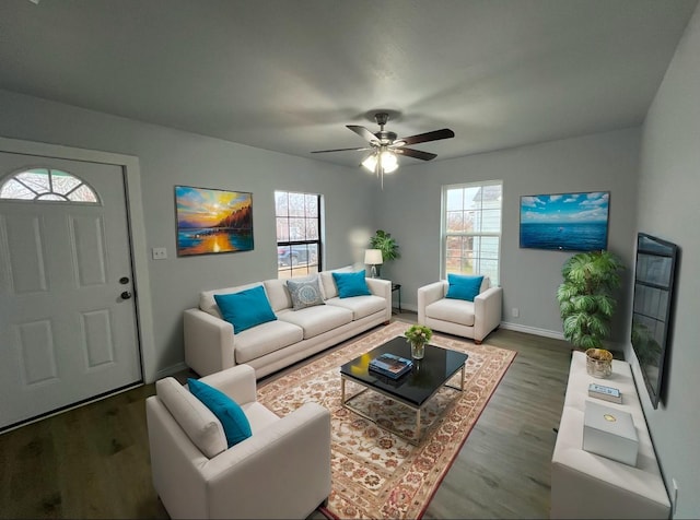 living room featuring dark wood-type flooring and ceiling fan