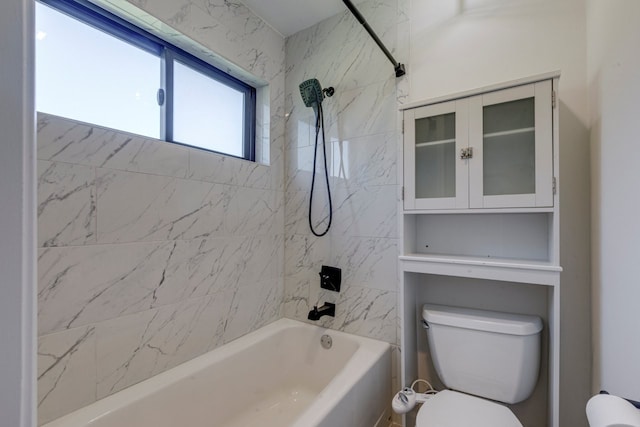 bathroom featuring tiled shower / bath combo and toilet