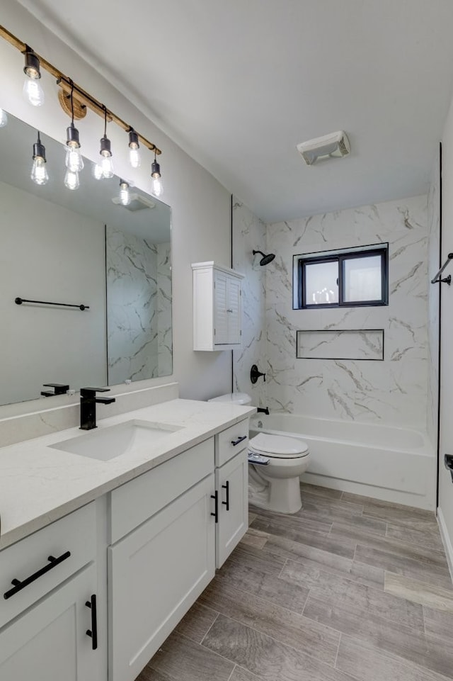 full bathroom with vanity, toilet, and tiled shower / bath