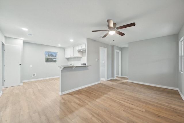 unfurnished living room with ceiling fan and light wood-type flooring