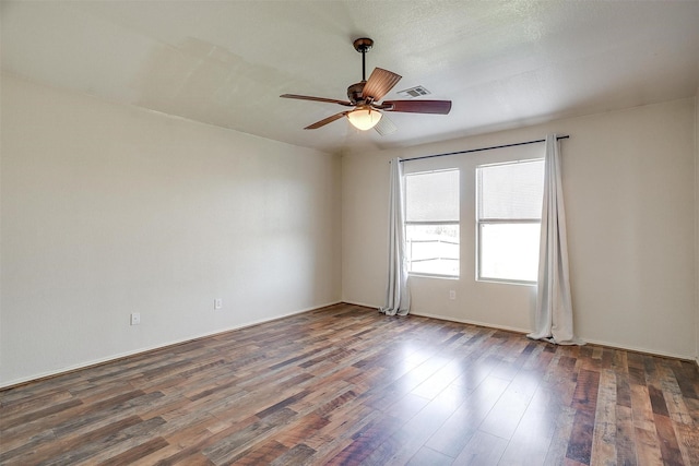 spare room featuring ceiling fan and dark wood-type flooring