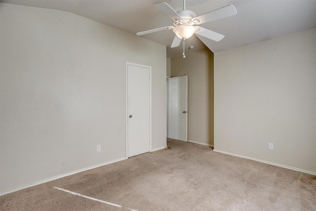 spare room featuring light colored carpet, ceiling fan, and lofted ceiling