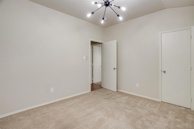 unfurnished bedroom with lofted ceiling, light colored carpet, and a notable chandelier