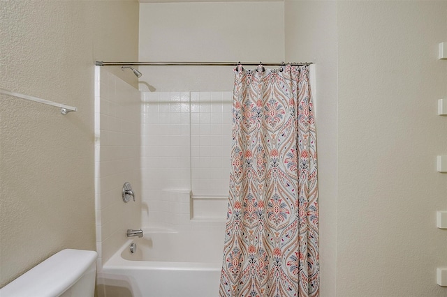 bathroom featuring shower / tub combo and toilet