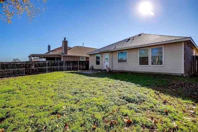 rear view of property with a yard