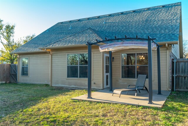 back of house with a pergola, a patio area, and a lawn