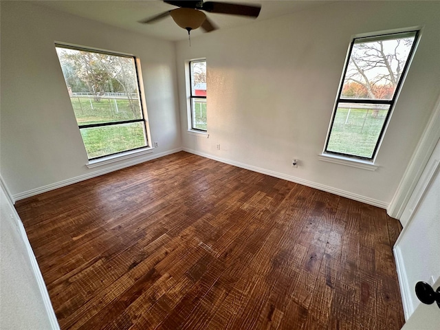 unfurnished room with ceiling fan and dark hardwood / wood-style flooring