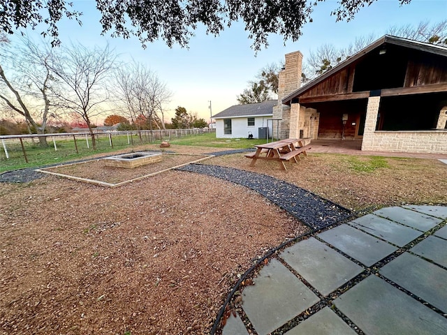 yard at dusk featuring a patio