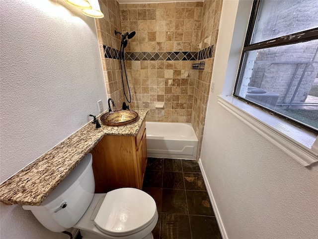 full bathroom featuring tiled shower / bath, vanity, toilet, and tile patterned floors