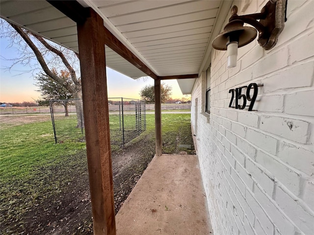 yard at dusk featuring a rural view