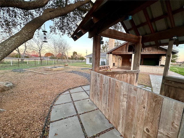 yard at dusk featuring a patio and central AC unit