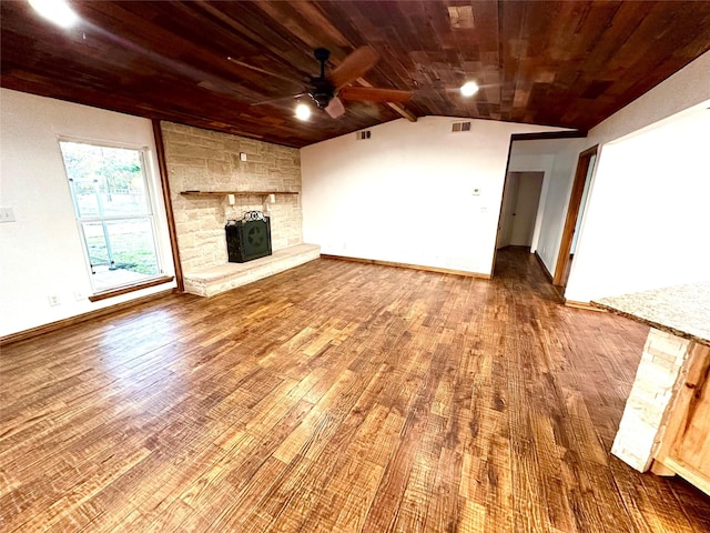 unfurnished living room featuring lofted ceiling, a stone fireplace, wood ceiling, hardwood / wood-style flooring, and ceiling fan