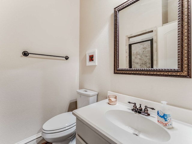 bathroom with vanity, toilet, and baseboard heating