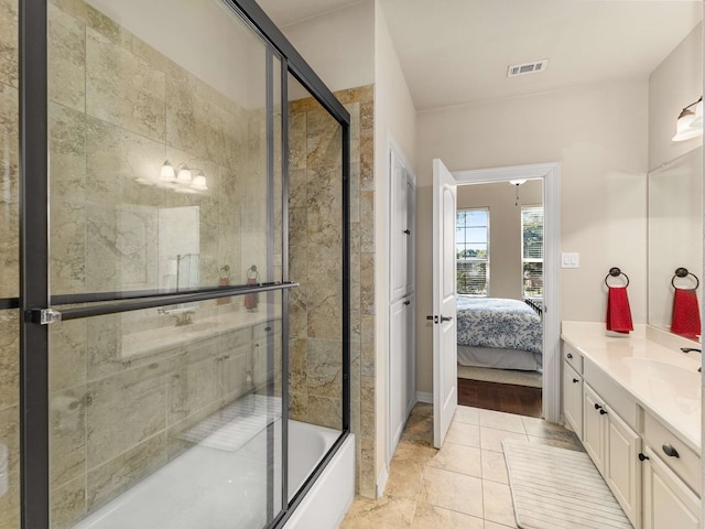 bathroom featuring tile patterned flooring, vanity, and shower / bath combination with glass door