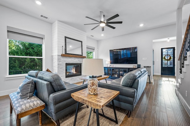 living room featuring ceiling fan, a fireplace, and hardwood / wood-style flooring