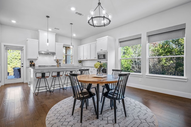 dining space featuring dark hardwood / wood-style flooring and a notable chandelier