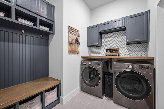 washroom with washer and clothes dryer, cabinets, and light tile patterned floors