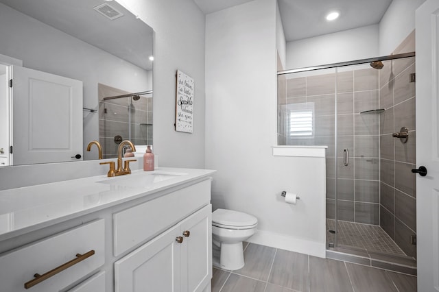 bathroom featuring vanity, toilet, and a shower with door