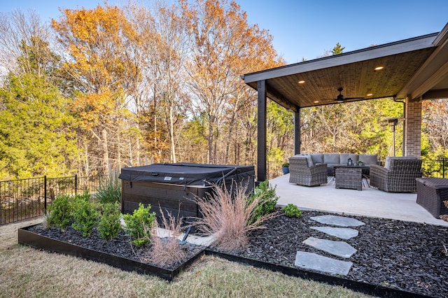 view of patio / terrace featuring an outdoor living space, ceiling fan, and a hot tub